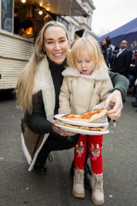 Mother and daughter enjoying their pizza in the VIP section at London's New Year's Day Parade.