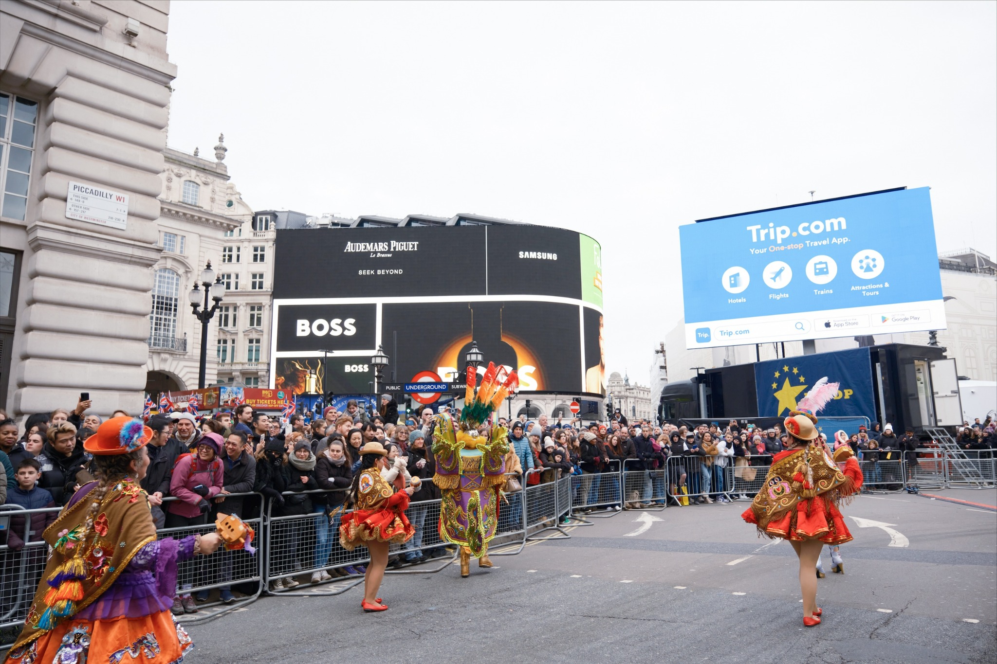 Colourful performers dancing in Piccadilly Circus parade, London.